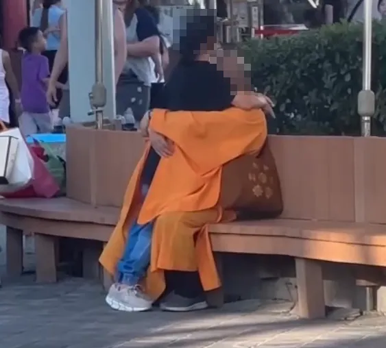 台北新樂園有民眾目擊1名穿袈裟的光頭男性緊抱女子,不少家長與小朋友從旁邊經過。(圖/翻攝自Facebook@爆料公社二社)
