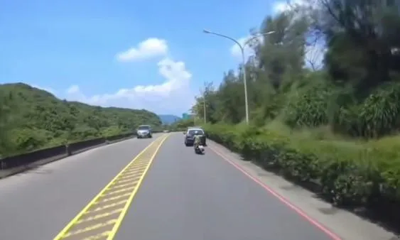 警車鳴笛但阿嬤仍繞過警車繼續往前騎。（圖／翻攝自「爆料公社」）