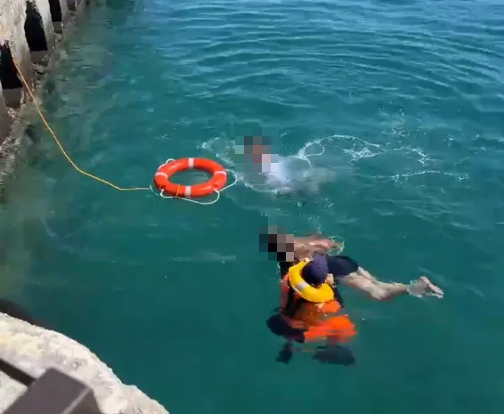 屏東小琉球白沙漁港碼頭8日發生男女跳海事件，海巡安檢人員連忙下水救人。（圖／民眾提供）