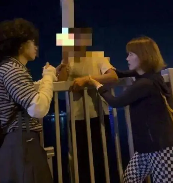 胡女與友人緊緊拉住要跳橋的男子（中）。（圖/翻攝《網易》）