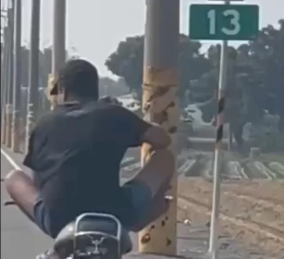 近日網路瘋傳一段令人咋舌的影片,一名疑似外籍移工在彰化道路上騎著微型電動車,雙腿盤坐在機車龍頭上,邊看手機邊吃盤面,宛如「特技表演」。(圖/社會事新聞影音,下同)