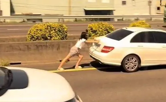 女駕駛在內線車道徒手推故障賓士車。（圖／翻攝自社會事新聞影音）