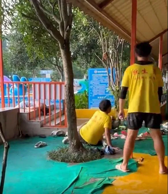 持木掃帚的救生員試圖撥開昏倒泳客，卻滑倒在地，四周傳出其他泳客的驚呼聲。（圖／翻攝微博@飛棉花絮）
