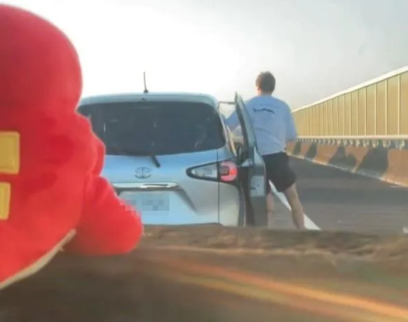 一輛自小客車在塞車時突然向右切換車道，隨後一名外籍男子竟直接下車。（圖／Threads／@barry07150715授權提供）