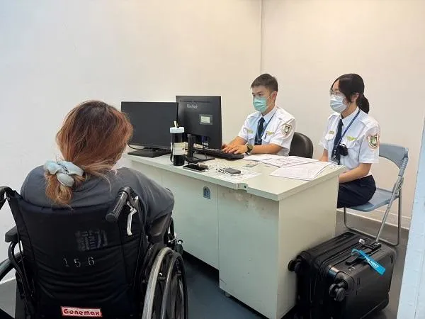 吳女涉嫌冒用他人護照出境，移民官依法進行訊問調查。（圖／移民署國境事務大隊）