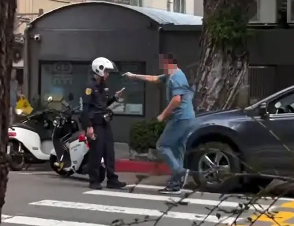 從目擊民眾拍攝的第三視角可見，張男持續伸手挑釁員警，期間不斷大吼。（圖／翻攝自黑色豪門企業）