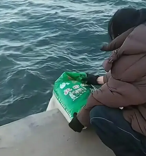 女子將大米傾倒至海中。（圖／翻攝《瀟湘晨報》）