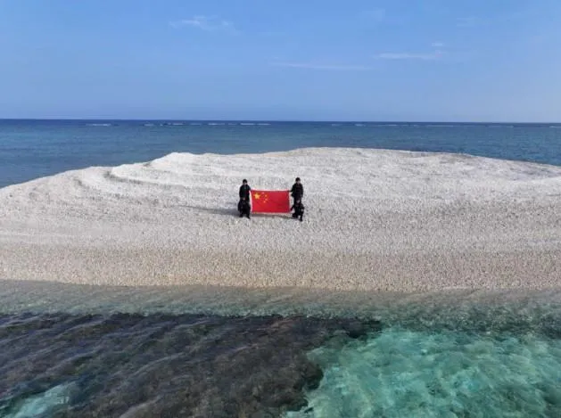 大陸海警日前登「鐵線礁」並展示五星紅旗。（圖／翻攝央視新聞）
