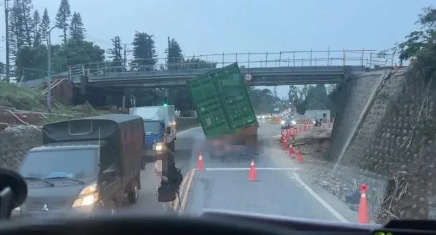 一台貨櫃車駕駛行經該路段時,疑似未注意高度設限高度,導致貨櫃車卡在高架橋底下。(圖/翻攝自記者爆料網)