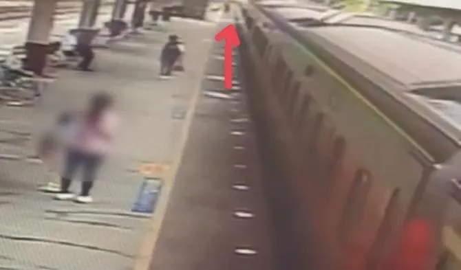 男子從月台跳上自強號車廂間夾縫攀附車身。（圖／翻攝畫面）