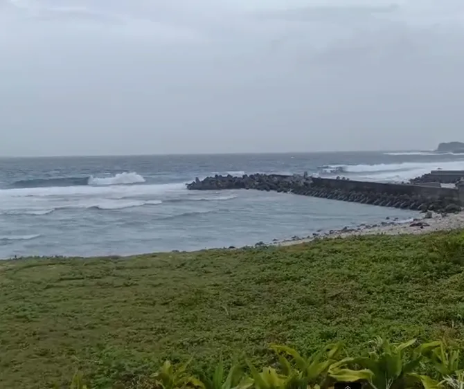 巴威颱風逼近，基隆潮境公園一早卻湧入大批觀浪人潮，現場甚至驚現兩層樓高的壯觀巨浪，吸引不少民眾頂風駐足。（圖／中天新聞）