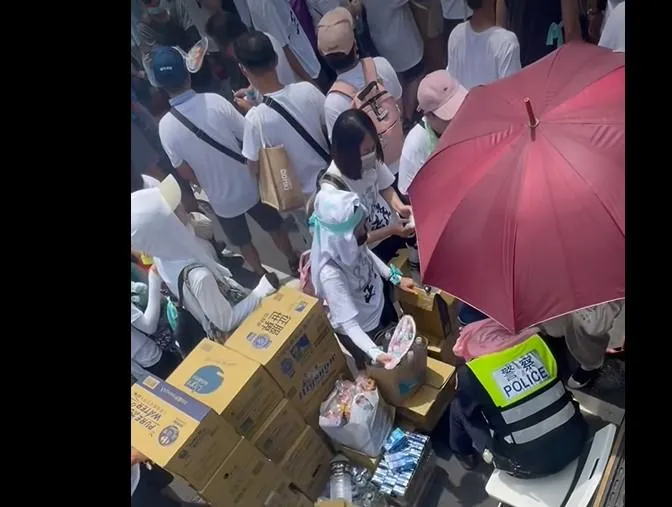 民眾黨支持者為身體不適警察搧風、撐傘。（圖／擷取自張志豪臉書）