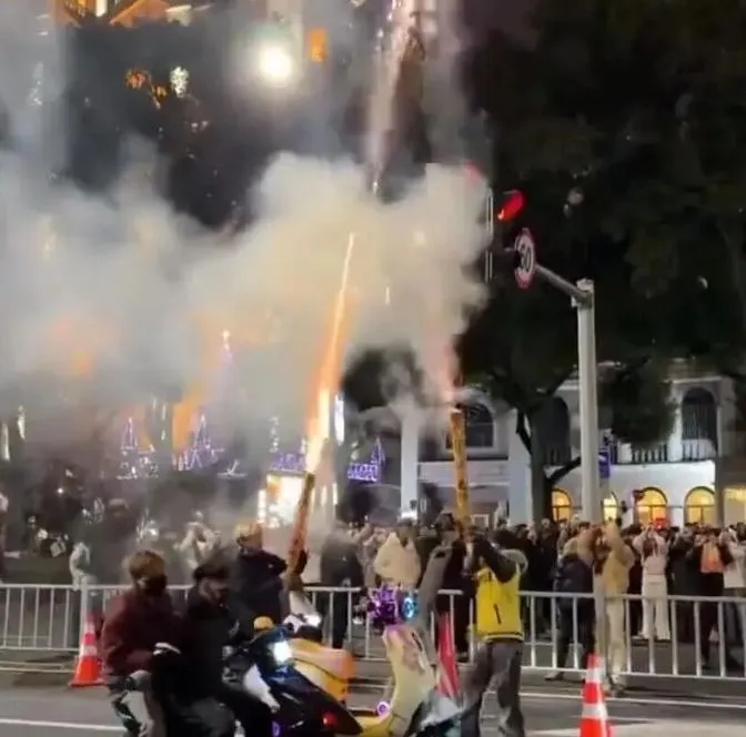 兩名男子在街頭放煙火。(圖/翻攝《京報網》)