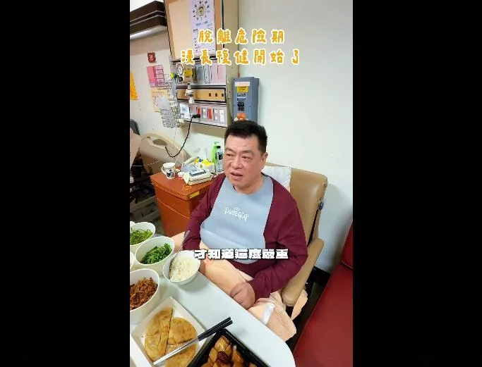 孫德榮13日上傳影片記錄病房進食情況，戴著圍兜以湯匙進食，餐桌上擺放白斬雞等菜餚。（圖／翻攝孫腫來了 臉書）