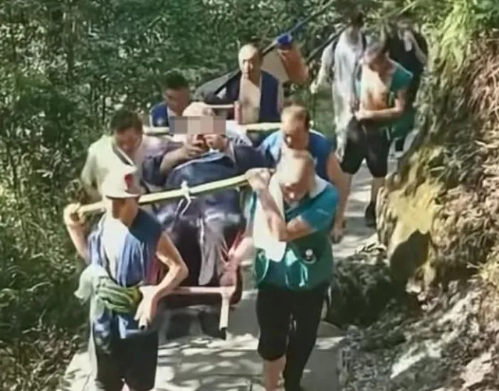 一名體重逾百公斤男子,由9名轎夫輪流抬上山。(圖/翻攝新浪微博)