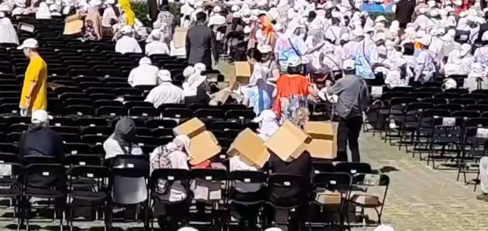 國慶大典現場艷陽高照讓民眾受不了用紙箱遮陽。（圖／中天新聞）