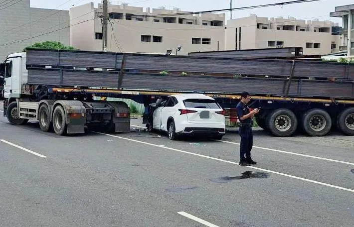 休旅車高速追撞前方拖板車，車體深深卡入底盤，現場畫面相當驚悚。（圖／中天新聞）