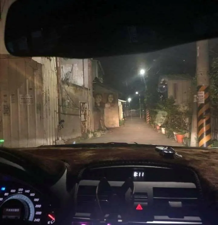 有民眾駕車到台中市某處暗巷正要停車，抬頭就看見對面1對夫婦掛著詭異微笑盯著他們。（圖／翻攝自Facebook@爆料公社）