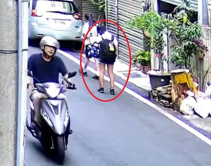 苗栗市1名48歲邱姓男子2日下午3時許赤腳騎車、左手纏水果刀出沒街頭,路口監視器拍下事發前邱嫌、受害徐童擦肩而過的畫面。(圖/翻攝畫面)
