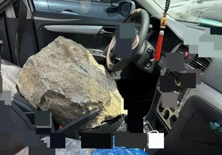 根據現場照片顯示，一塊大石砸進車內，觸目驚心。（圖/翻攝《鳳凰網》）