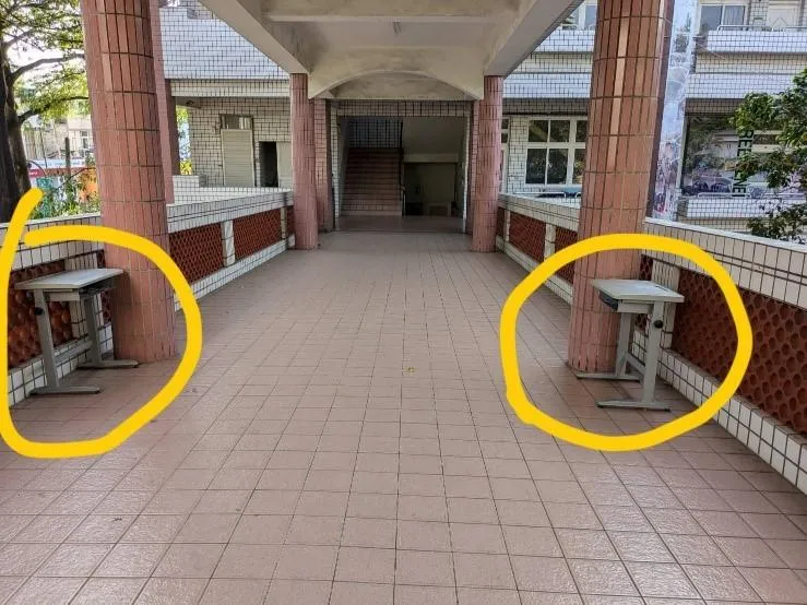 網紅老師將兩張課桌擺放在教學大樓連接走廊女兒牆旁邊。（圖／取自高雄市教師職業工會網站）