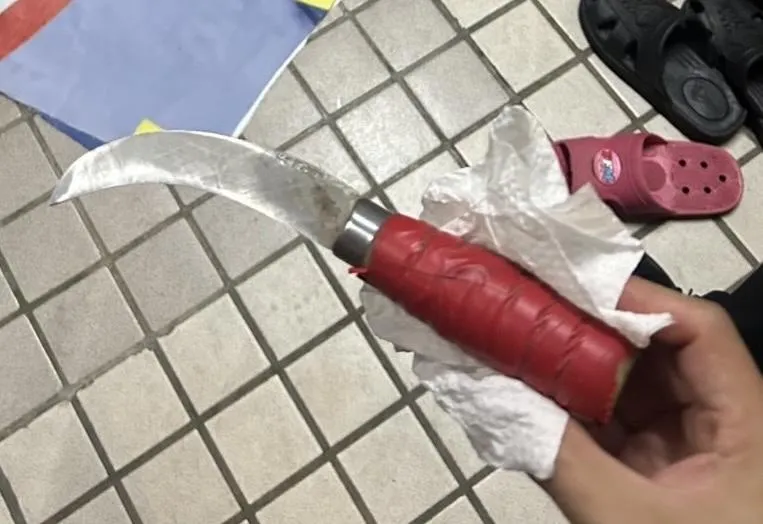 老翁割宣傳布條用鐮刀。（圖／翻攝畫面）