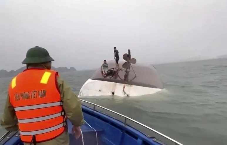 觀光船翻覆後，有船上人員攀在船隻待救。（圖／美聯社）