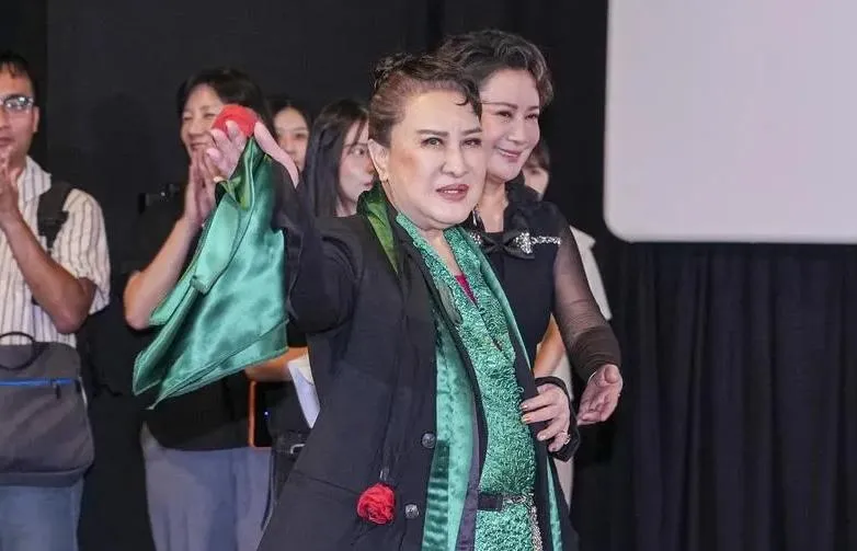 台灣國寶級歌仔戲演員楊麗花13日在台北出席紀錄片《世紀初戀 楊麗花》全球記者會，現場揚起手中布巾，一展昔日舞台身段風采。（圖／中央社）