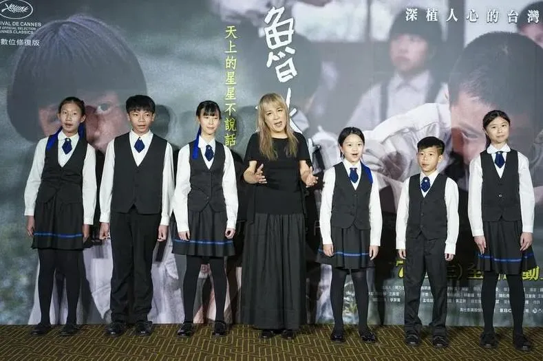 電影《魯冰花》數位修復版台北首映會7日晚間舉行,同名主題曲演唱者曾淑勤(中)與拉縴人少年兒童合唱團清唱主題曲〈魯冰花〉,勾起跨世代觀眾共同回憶。(圖/中央社)