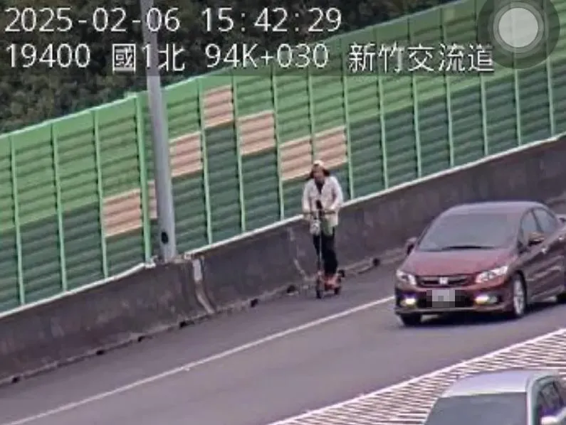 男子騎電動滑板車,沿國1路肩滑行。(圖/翻攝畫面)