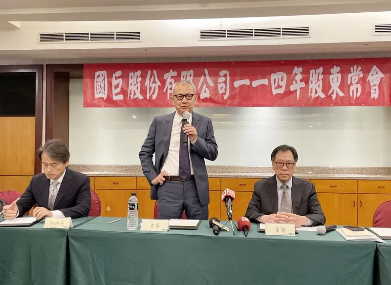 圖為國巨董事長陳泰銘(站立者),強調併購日本芝浦電子「不屈不撓」。 (圖/中央社)