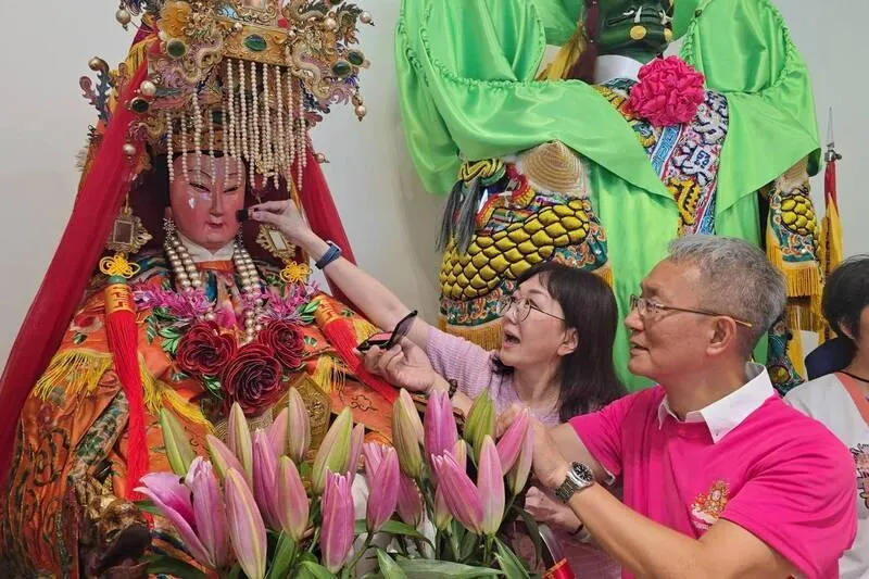 被暱稱為「林小姐」的主祀宮廟南方澳進安宮媽祖16日現身宜蘭新月廣場舉行「點妝見客」儀式,由宜蘭縣代理縣長林茂盛(前右)等人代表獻上化妝品,為媽祖點妝。(圖/中央社)