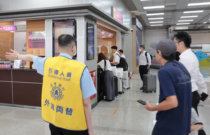 圖為銀行人員引導旅客兌換新台幣。（示意圖/中央社）