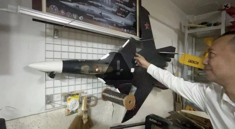 在彰化眼鏡行老闆洪尚仁的「地下空軍基地」中,掛在牆上的SU-47戰機模型是得意作品,洪尚仁說,由於造型太特殊,經不斷嘗試,才讓戰機模型順利升空。(圖/中央社)