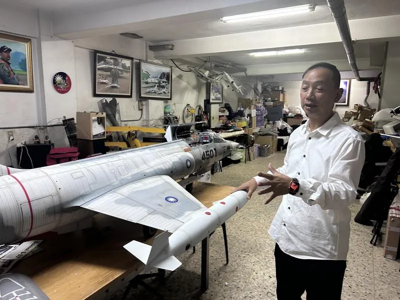 在彰化市經營眼鏡行的洪尚仁懷抱飛行夢,自製遙控戰機模型,也讓眼鏡行地下室成另類空軍基地。(圖/中央社)
