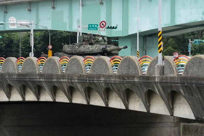 砲塔覆蓋偽裝網的M1A2T戰車，行駛通過桃園的領航南橋。(圖/中央社)
