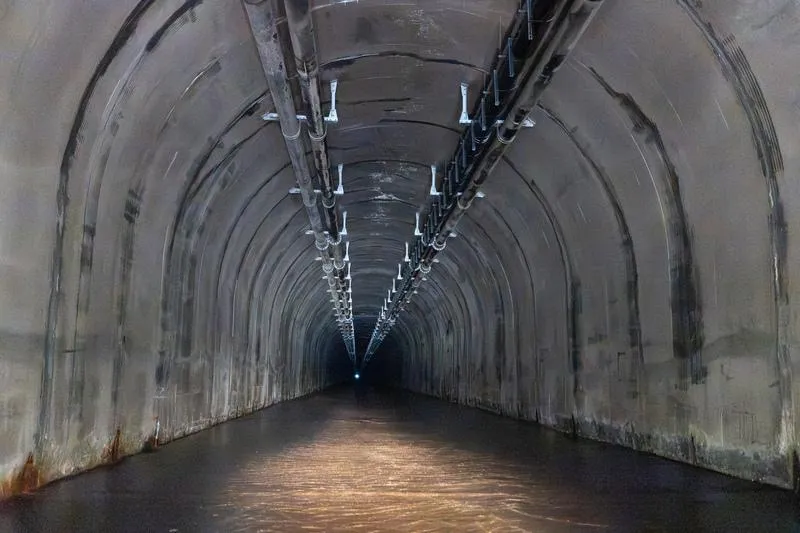 石門水庫阿姆坪防淤隧道結合輸泥管與水力沖淤，可減少水庫中游淤積。圖為隧道內，上方管道為輸泥管。（圖／中央社）