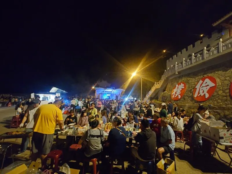 迎接中秋佳節，連江縣東引鄉公所提前在24日晚間舉辦一年一度的秋節月光派對，民眾齊聚在東引中柱門前廣場烤肉，氣氛熱鬧。（圖／中央社）