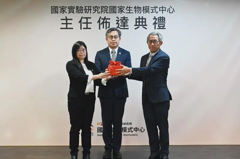 生物模式中心前主任秦咸靜(左)將印信交給主任張芳嘉(右),國研院院長蔡宏營(中)監交。(圖/中央社)