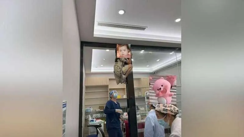 女童害怕看牙，竟敏捷地爬上門框。（圖／翻攝微博）