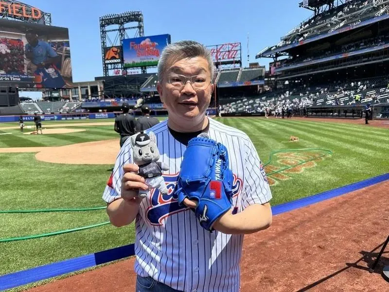 中華職棒大聯盟會長蔡其昌26日帶著歐告娃娃和繡有國旗與英文台灣的特製藍色手套現身紐約市花旗球場,為大都會台灣日活動開球。(圖/中央社)