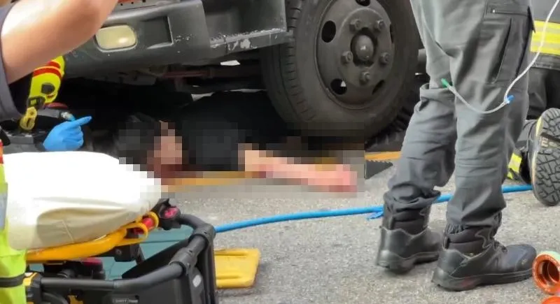 台中一名23歲男子過馬路時，遭左轉小貨車撞倒並捲入車底輾過。（圖／翻攝畫面）