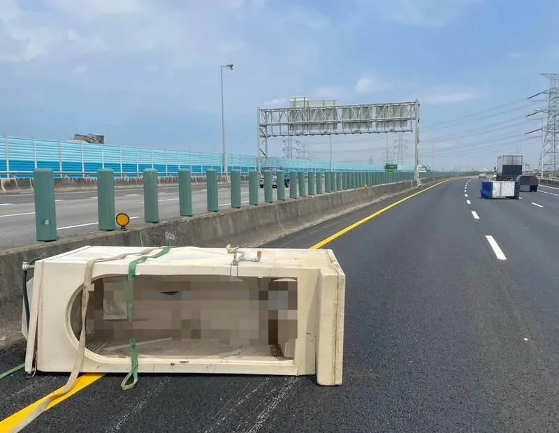 一輛大貨車行經國道3號北向190.5公里彰化和美路段時，車上載運的2座流動廁所與1個大型不鏽鋼水塔疑因未綑紮牢固，突然甩落在國道車道上。（圖／警方提供）
