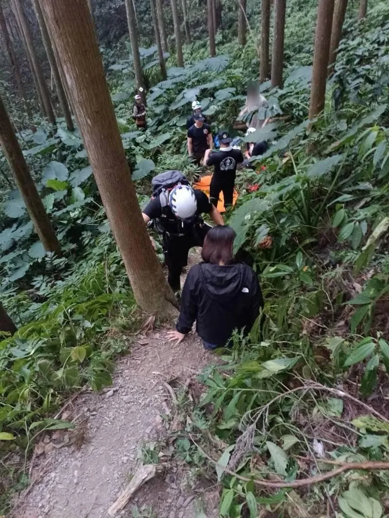 搜救人員以捲式擔架將女登山客搬運下山送醫。（圖／南庄消防分隊提供）