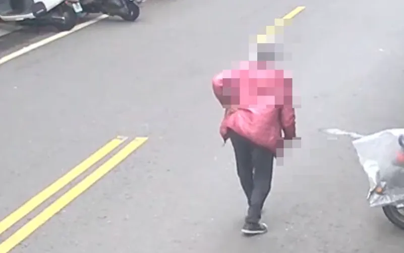 老婦手持疑似水果刀或美工刀類的刀具在街頭行走。（圖／翻攝畫面）