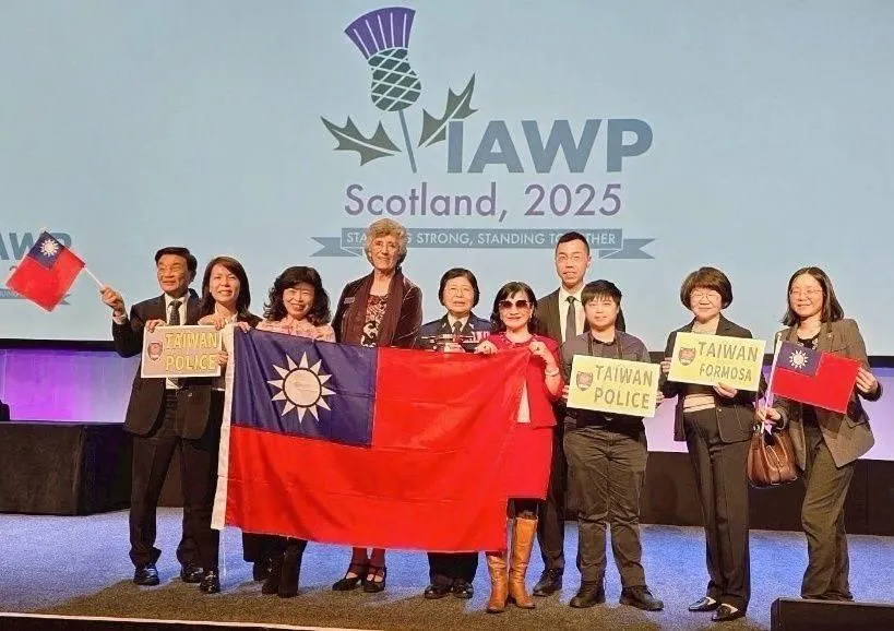廖副署長親友團特地帶著國旗到英國觀禮上台合照。（圖／翻攝畫面）