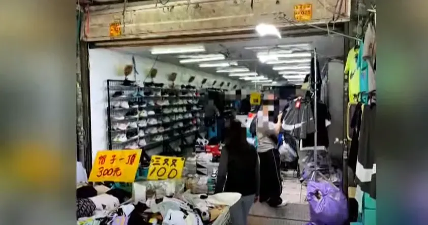台北市信義區吳興街菜市場一間攤販賣價格低廉的Nike運動用品，引發民眾質疑，並向警方檢舉。（圖／中天新聞）