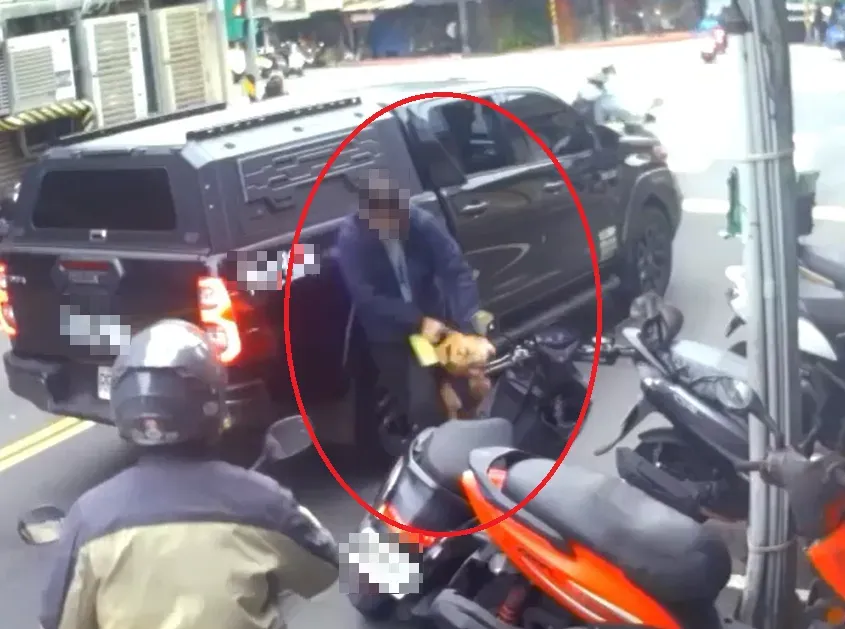 徐男費了一番功夫才讓愛犬鬆口,他將愛犬帶回車上。(圖/翻攝畫面)