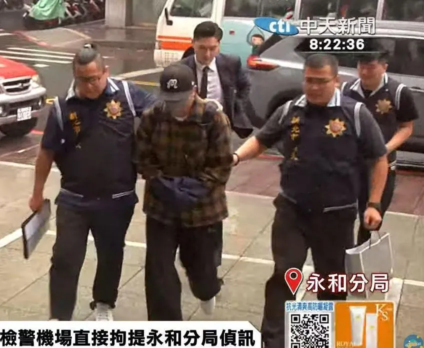 今天返台的坤達被上銬押進永和分局偵訊。（圖／中天新聞）