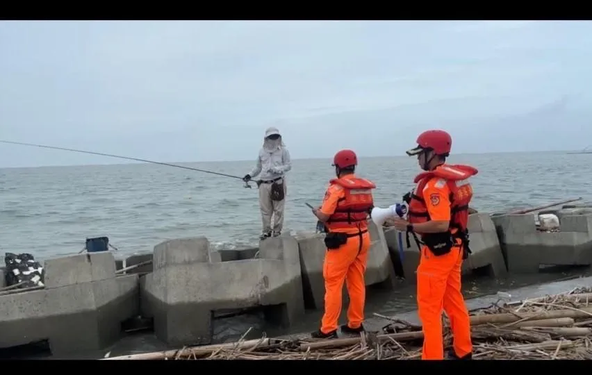 海巡人員勸離民眾在颱風天海邊釣魚行為。（圖／海巡署）